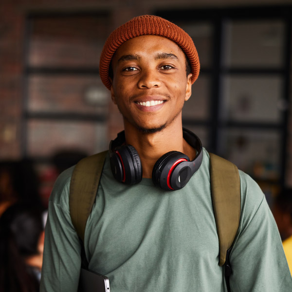 man smiling with headphones around neck